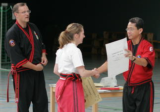Grandmaster Rene Tongson und Senior Master Datu Dieter Knüttel verleihen Katrin Schloßhauer nach bestandener Prüfung den Grad Dayang Isa (1.Dan)